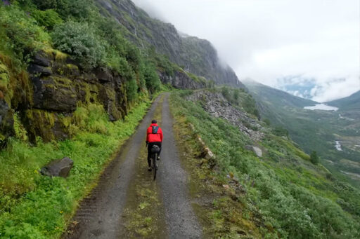 Cyclist on gravel hill road, Norway